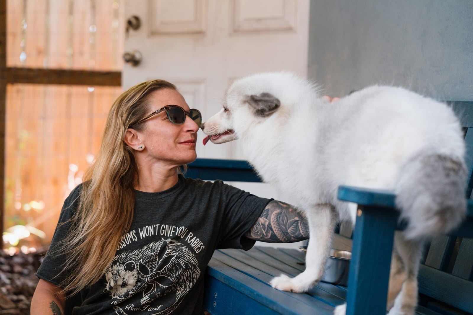 A sanctuary caregiver bonding with a rescued white fox at Pawsitive Beginnings